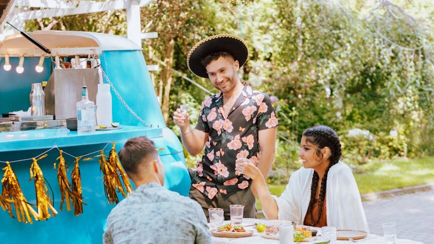 a group of friends eating and drinking in outdoor setting